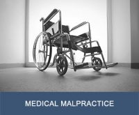 Looking up at empty wheelchair with text "medical malpractice" on bottom