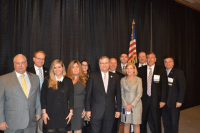 Lineup of JW Associates with a black curtain and American flag in the background